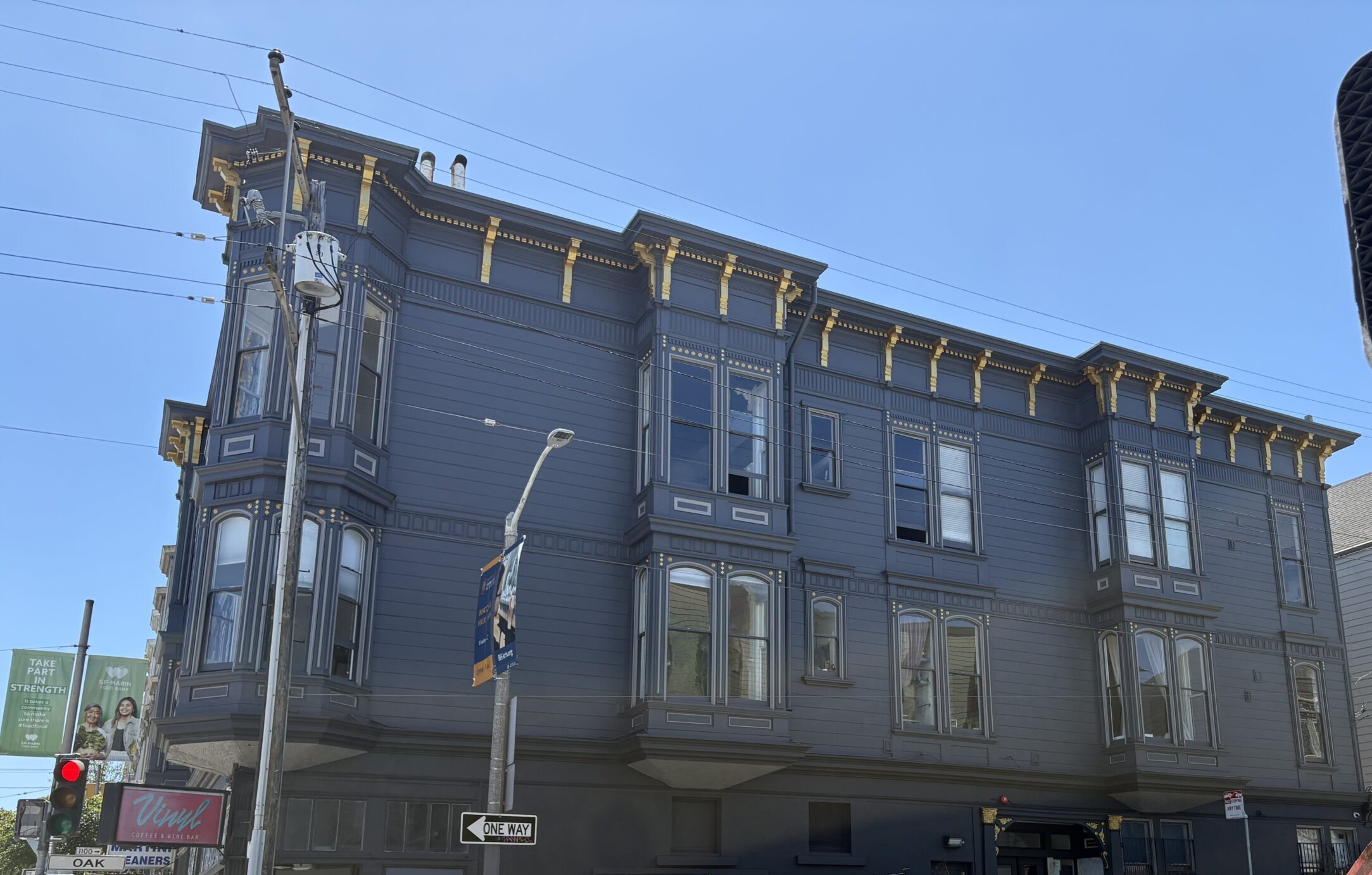 Restored blue and gold Victorian building in NOPA, San Francisco, after full exterior restoration by Maven Maintenance